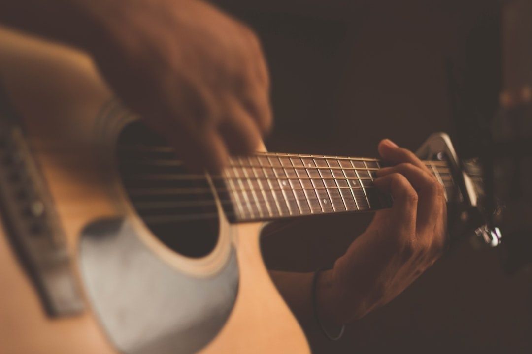 Close-up van handen die een akoestische gitaar bespelen