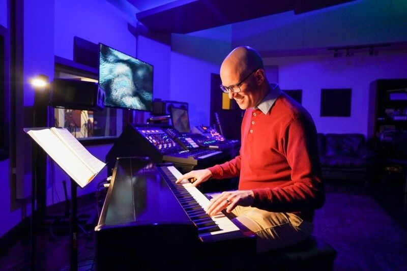 Muzikant speelt piano in een kleurrijke muziekstudio