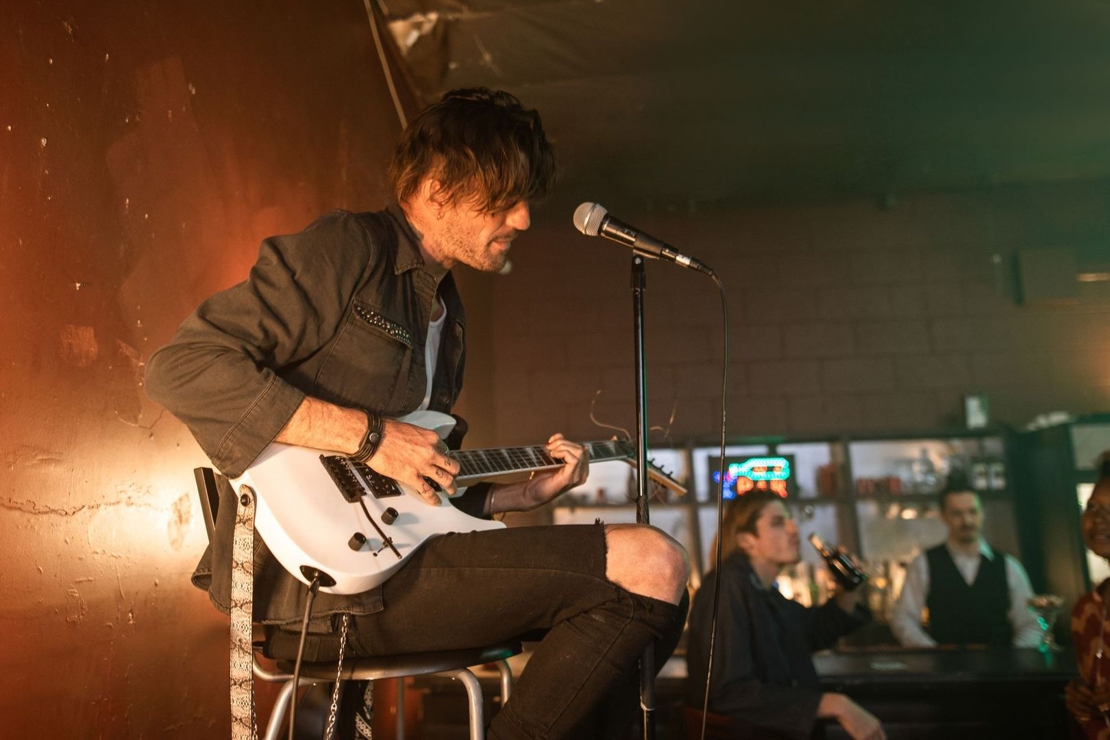 Gitarist zingt op een podium tijdens een liveoptreden